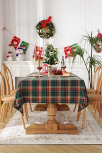Detail of red and green plaid Christmas tablecloth with tassels in a festive setting