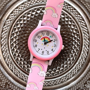 Close-up of pink silicone watch strap with rainbow and cloud patterns on metal tray