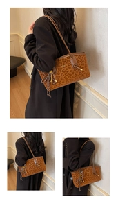 Détail du sac cabas léopard avec lanières brunes et breloque cadenas en métal doré