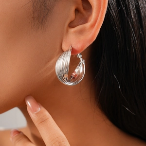 Close-up of a silver multi-layered circular earring worn on model for a stylish look