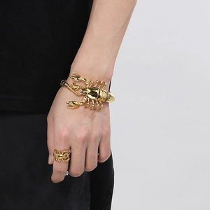 Détail d'un ensemble bracelet et bague scorpion doré en acier inoxydable sur mannequin