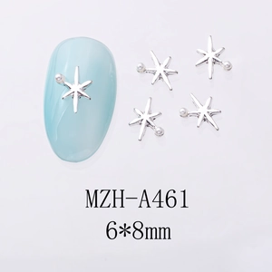 Vue macro de breloques à ongles étoile argentée avec perles blanches sur ongle