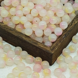 Macro detail of 8mm pink and yellow gradient glass round beads for DIY jewelry making
