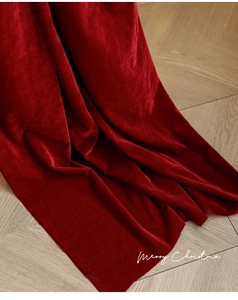 Close-up of premium red velvet fabric showing soft texture and natural drapes on floor
