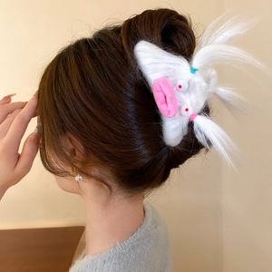 Close-up of white plush monster hair claw clip with pink lips and red eyes detail