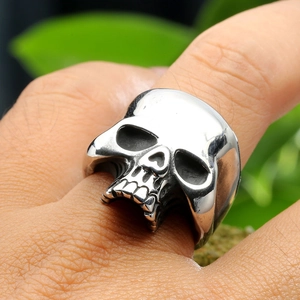 Macro shot of punk skull ring with detailed engravings and polished silver finish