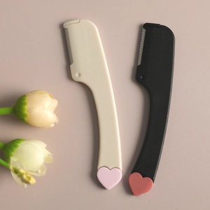 Mini eyebrow razors in beige and black with heart detail and protective safety blades