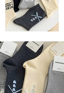 Detail grauer Crew-Socken aus Baumwolle mit Herz-Stickerei und hellblauer Seidenschleife