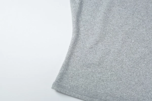 Macro shot of heather grey knit fabric detail with double-needle stitching on the hem
