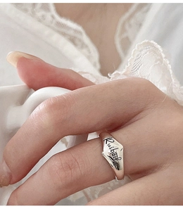 Macro shot of irregular silver bamboo ring with Ruibeila engraving on fingers