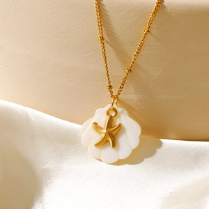 Vue détaillée du collier en métal doré avec pendentif en coquillage blanc et petite étoile de mer