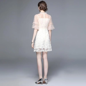 Robe élégante en dentelle blanche avec broderie et manches bouffantes, vue de dos