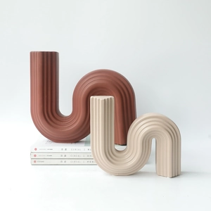 Modern S-shaped ceramic vases with vertical ribbing in brick red and beige matte finish