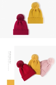 Détail de bonnets en maille côtelée avec pompons en fausse fourrure en rouge jaune et rose
