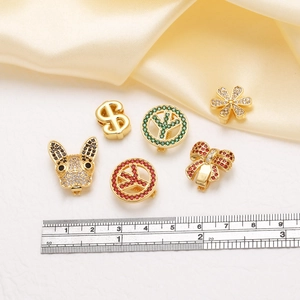 Detail von vergoldeten Anhängern mit bunten Zirkoniasteinen und Schleifen-Details
