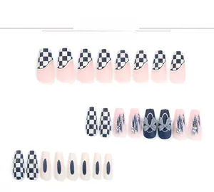 Detail of checkerboard press-on nails with blue ribbons and pearl accents for women