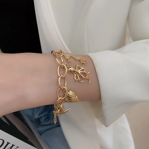 Detailed view of gold ocean charms bracelet with seahorse and starfish on model wrist