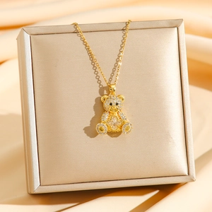 Funkelnde Teddybär-Halskette mit Kleeblatt-Motiv auf einem goldenen Schmuckständer