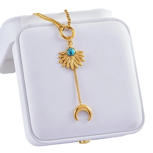 Gold layering necklace with turquoise sunflower and crescent moon charms on gift box