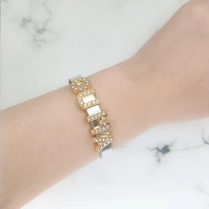Detail showing the OUMA sparkling gold letter charms on a silver rhinestone wristband