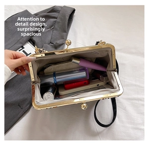 Detail view of the spacious inner compartment of this shell bag with beaded chain strap