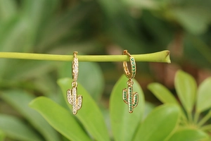 Boucles d'oreilles cactus dorées avec zircons verts et blancs sur branche naturelle