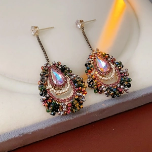 Close-up of vintage crystal teardrop tassel earrings with colorful bead accents
