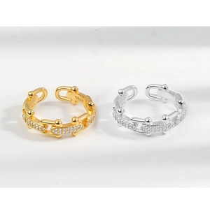Close-up of gold and silver S925 sterling silver chain rings with pave crystals