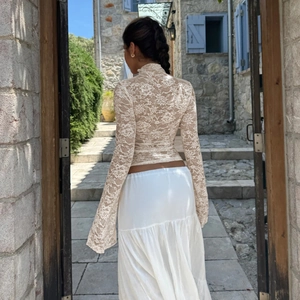 Haut chic en dentelle à manches longues et jupe blanche à volants en rue européenne