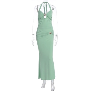 Detail of mint green halterneck dress featuring ruched waist and metallic buckle accents