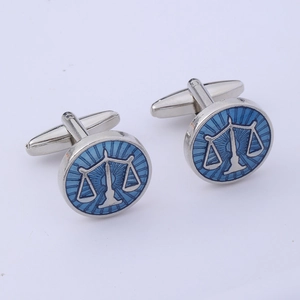 Detailed view of silver cufflinks featuring a blue scales of justice pattern on white background