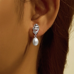 Close-up of S925 silver croissant stud earrings with elegant teardrop pearl drops