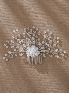 Close-up of handmade bridal hair comb with crystal beads and silver leaf branch design
