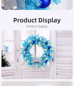 Close-up of blue Christmas wreath with silver ornaments and warm glowing LED lights