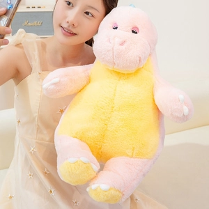 Close-up of pink and yellow plush dinosaur toy with detailed embroidery in a cozy setting