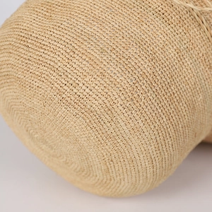 Detailed macro shot showing dense spiral hand-woven raffia texture on a beach hat