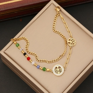 Detail of gold double-layer bracelet featuring tree of life charm and colorful beads