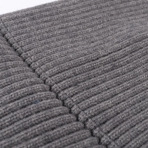 Close-up of thick grey ribbed knit texture and stitching on winter beanie hat