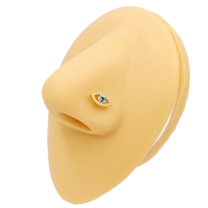 Gros plan d'un piercing nez œil grec doré avec zircons sur un nez en silicone