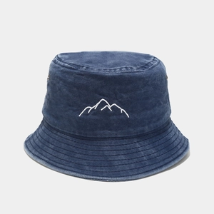 Detail showing white mountain peak embroidery on washed navy blue cotton bucket hat