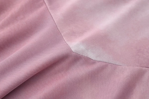 Macro detail of pink breathable mesh fabric with premium flat stitched seams on the dress
