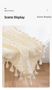 Close-up of white linen table runner with daisy embroidery and delicate fringe edges