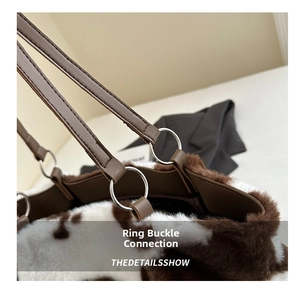 Detail of faux fur tote bag with cow print pattern and leather strap silver ring connector
