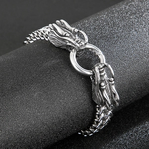 Detailed macro shot of vintage dragon head clasp on steel chain bracelet for men