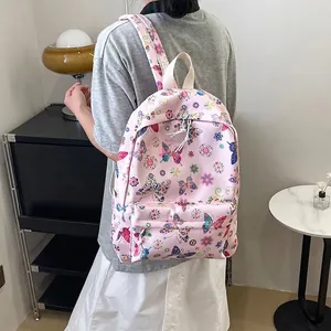 Zaino rosa con farfalle e fiori colorati, dotato di una tasca frontale con cerniera