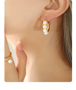 Close-up of elegant gold earrings and matching ring set with lustrous white pearls