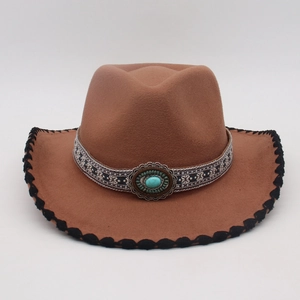 Detail of turquoise ornament and geometric woven band on a brown wool felt fedora hat
