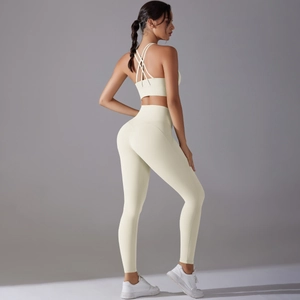 Detail view of the criss-cross back sports bra and high-waisted yoga leggings in cream