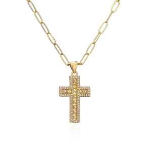Macro detail of 18K gold paperclip necklace with cross pendant and yellow gemstone