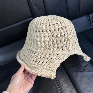 Detailed view of beige hollow knit crochet sun hat featuring intricate woven patterns